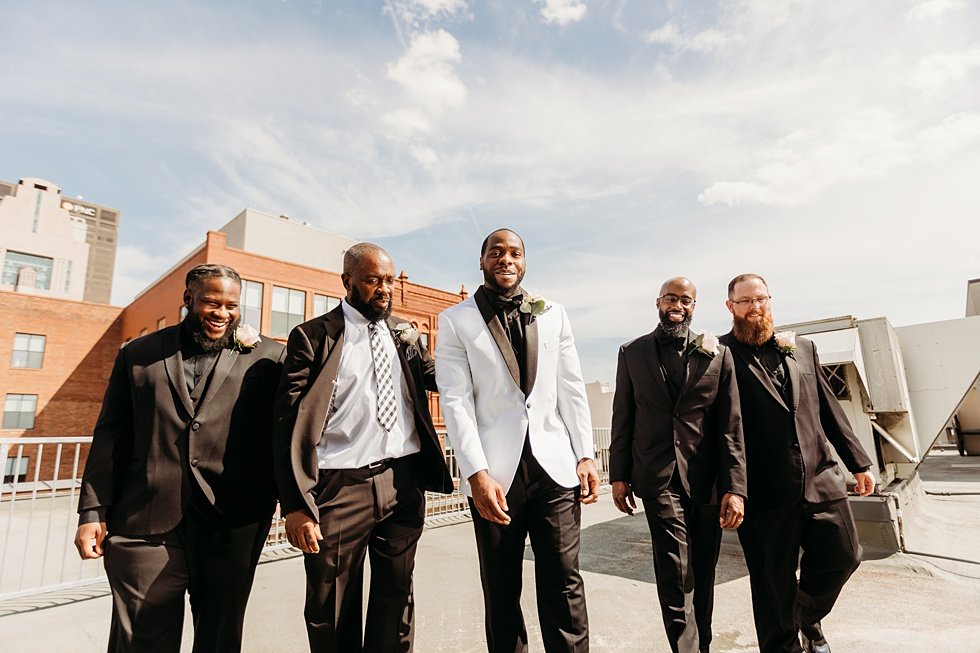  Groom posing with groomsmen. Rooftop wedding and reception at 21C Hotel Louisville 