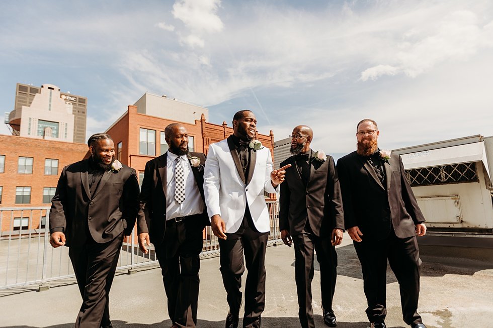  Groom posing with groomsmen. Rooftop wedding and reception at 21C Hotel Louisville 