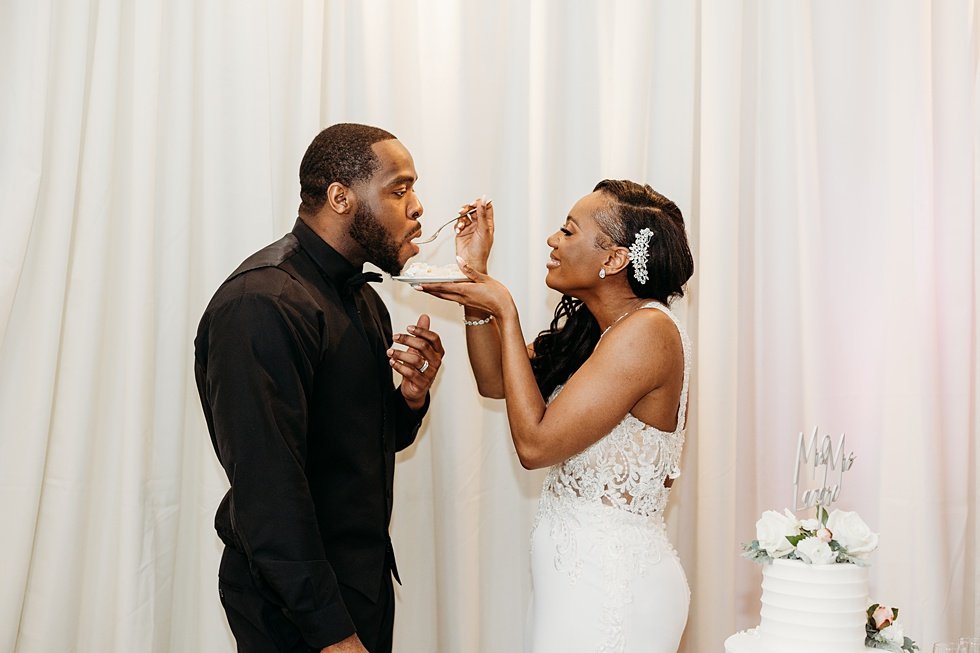  Couple cutting cake at 21c. Wedding reception at 21c Hotel Louisville. Rooftop wedding and reception at 21C Hotel Louisville 