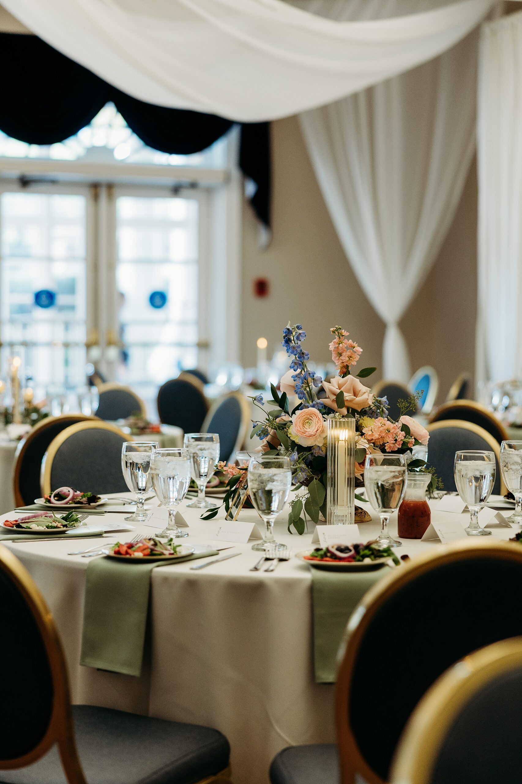 Reception table centerpiece with florals during a Gardencourt wedding reception indoors