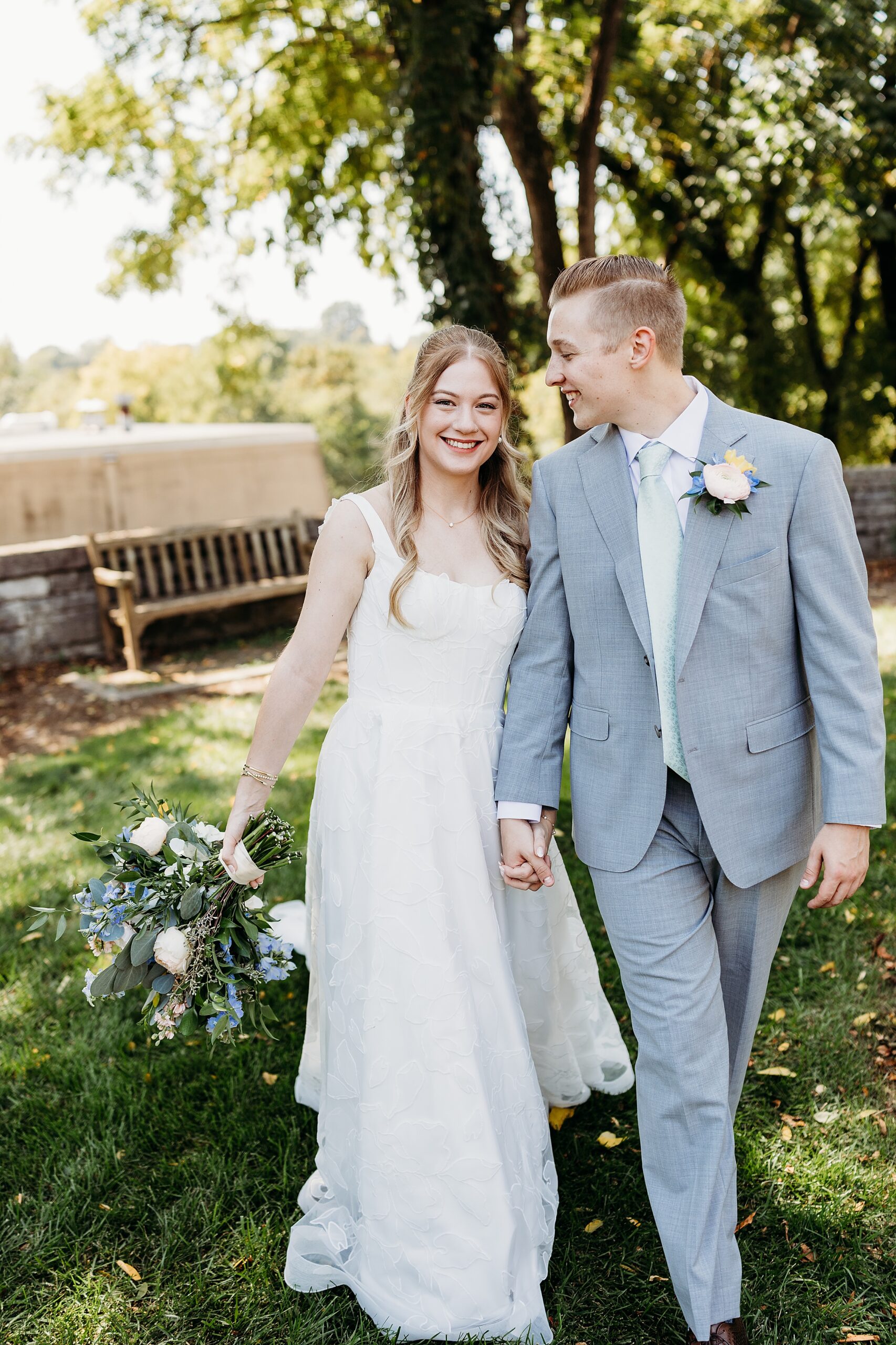 Bride and groom walking together during a Gardencourt wedding reception outdoors
