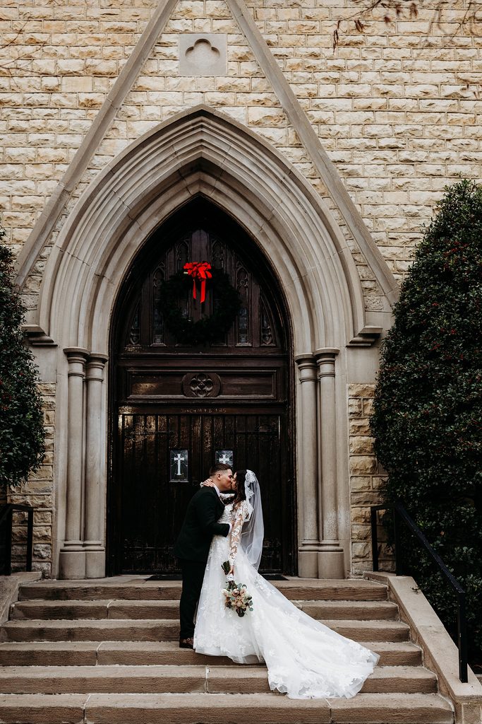 Bride and groom kiss outside St. Louis Bertrand Catholic Church in Louisville, KY