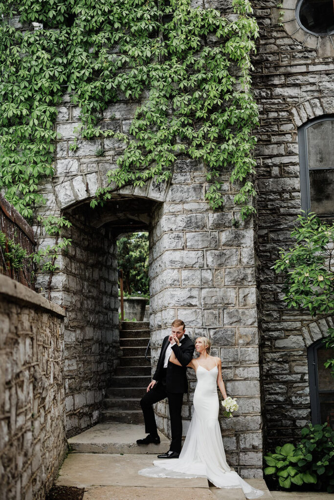 Castle & Key wedding portrait beside an ivy-covered stone archway.