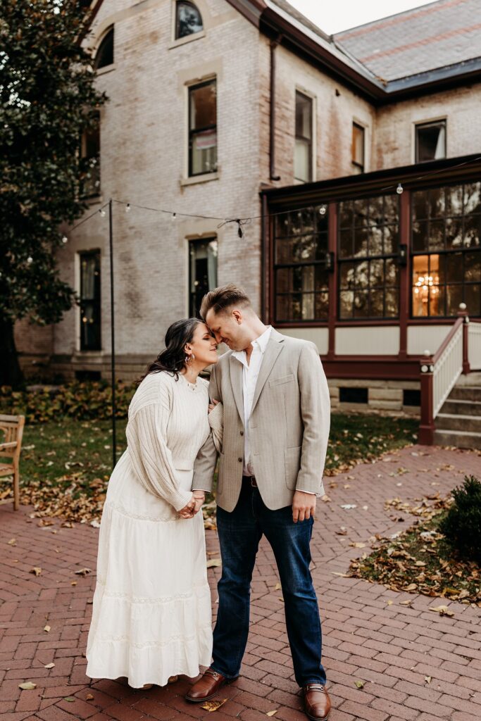 Heartland of Versailles couples portrait outside historic estate with romantic courtyard setting and brick exterior.