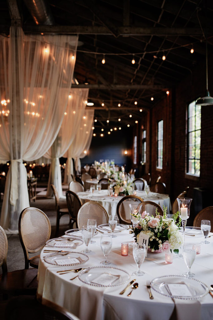Castle & Key Shook Building reception tables with floral centerpieces, draping, and string lights.