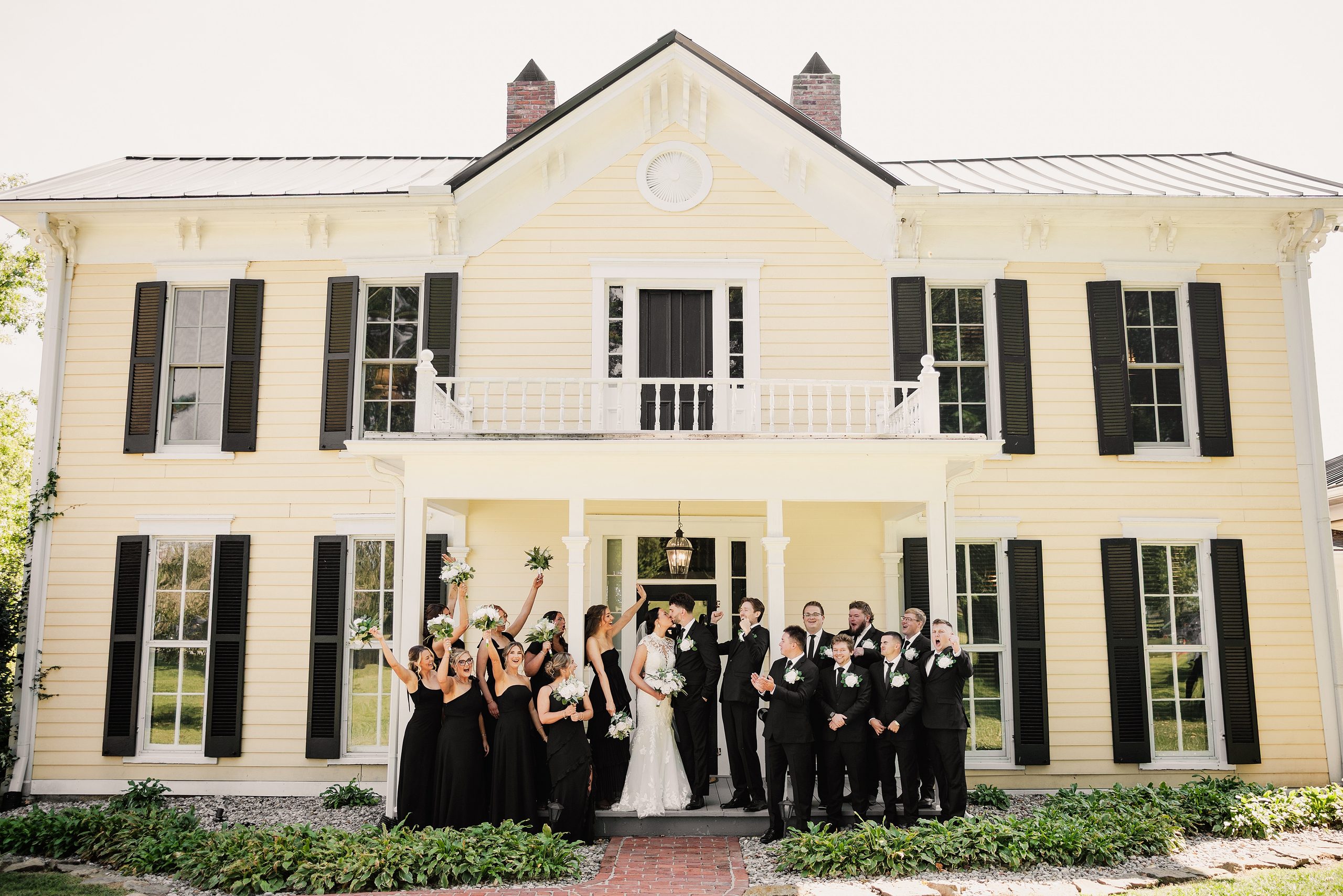 Wedding party celebrates with the bride and groom outside Bradshaw Duncan House.
