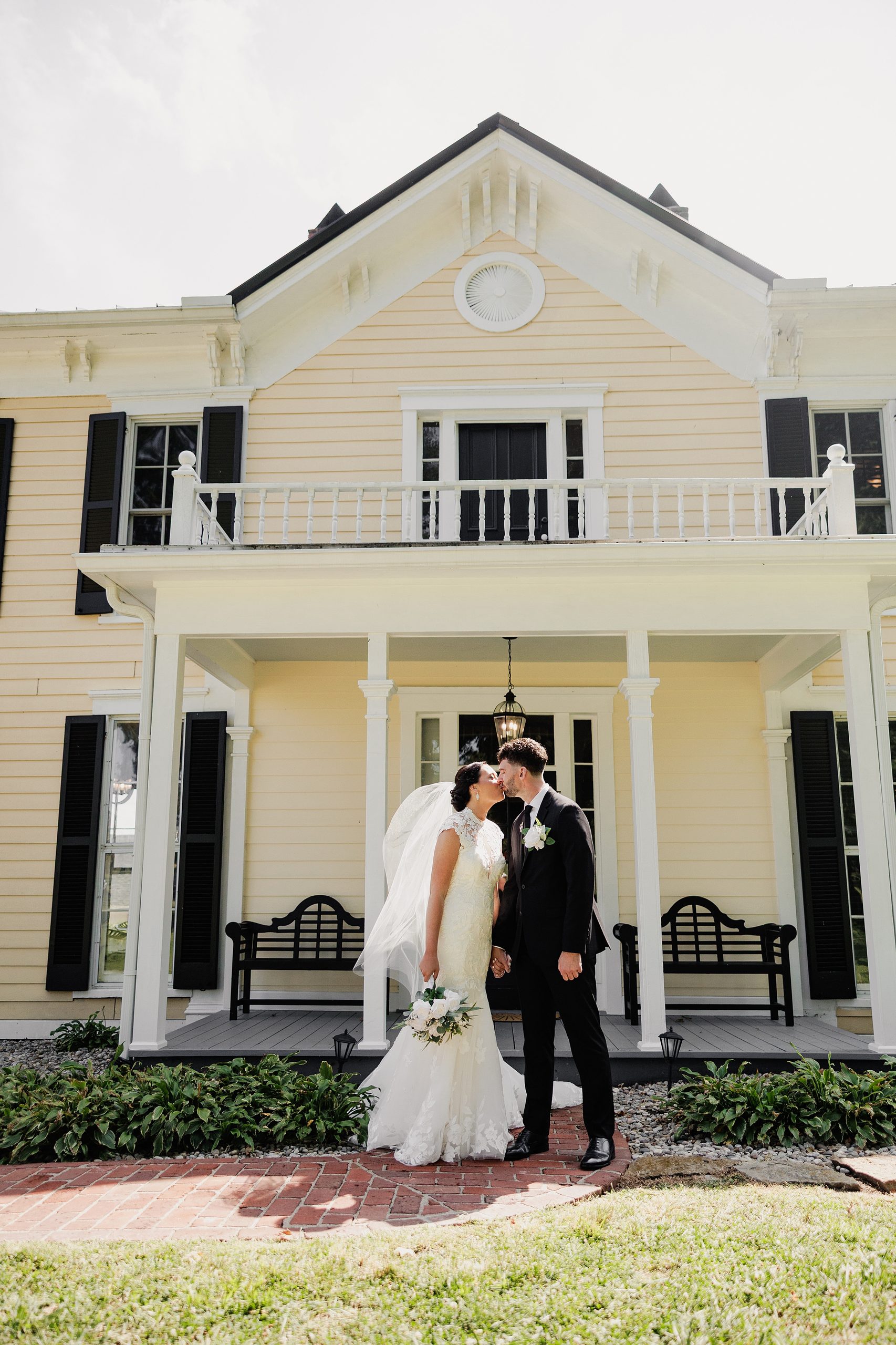 Bride and groom kiss in front of Bradshaw Duncan House on their wedding day.