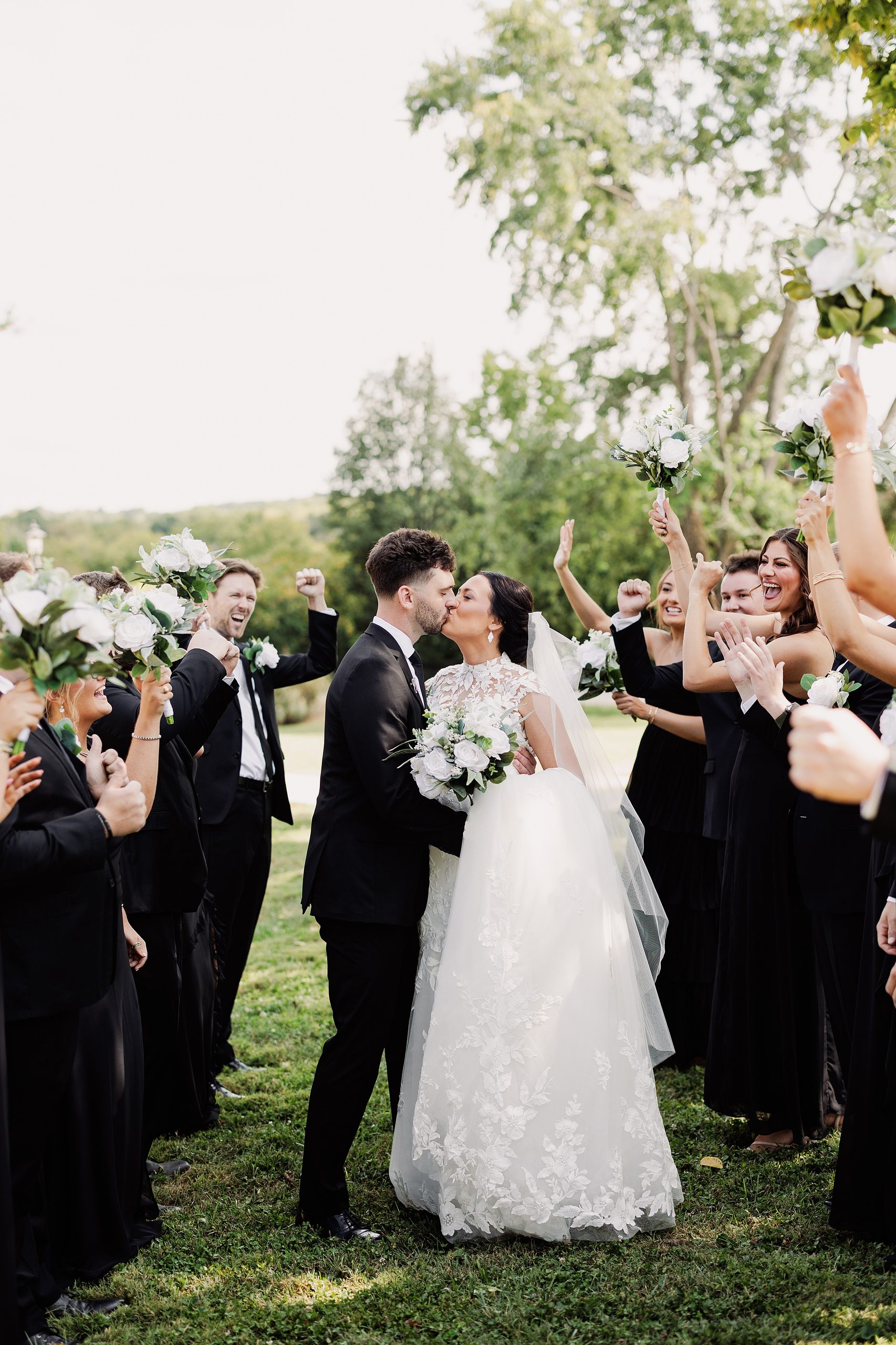 Wedding party celebrates with the bride and groom outside Bradshaw Duncan House.