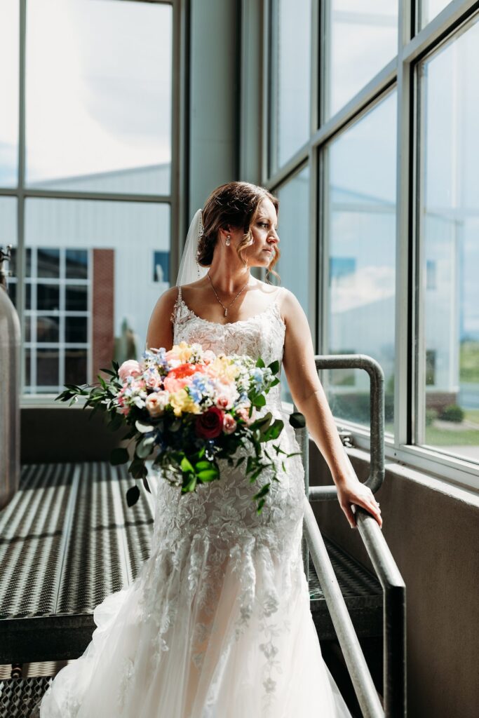 Bride looking out window in still room at Huber's Winery.