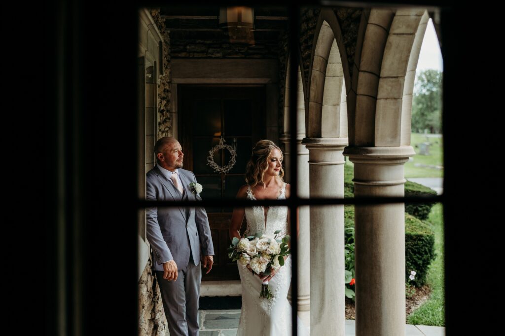 Bride and groom sharing a quiet moment beneath Duncan Memorial chapel arches before their wedding ceremony