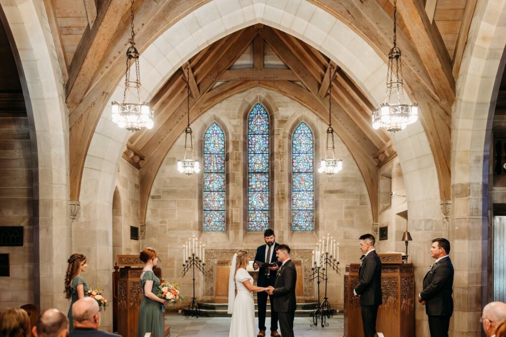 Bride and groom hold hands at Duncan Memorial Chapel ceremony.