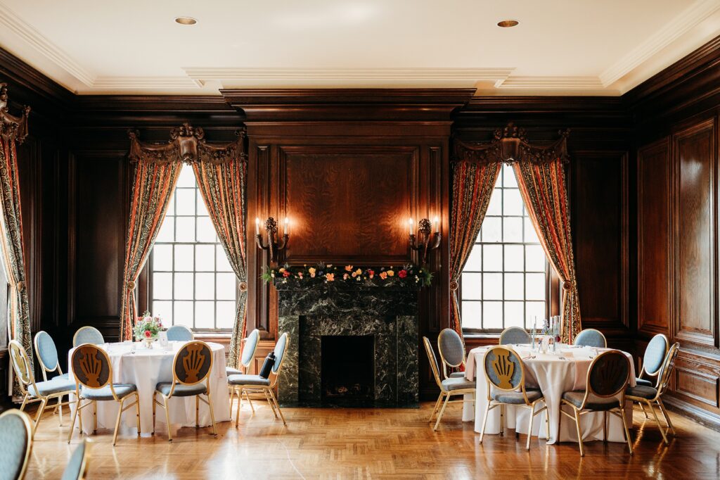 Garden Court reception room featuring a grand marble fireplace, wood paneled walls, and elegant wedding reception tables.