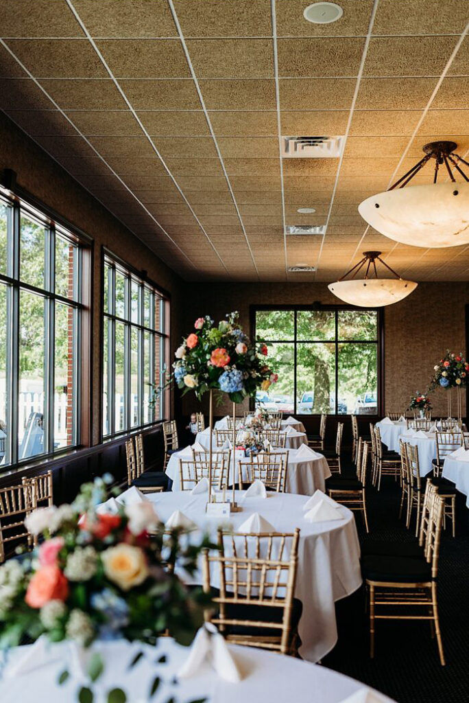 Small reception setup with tables, chairs and spring flowers.