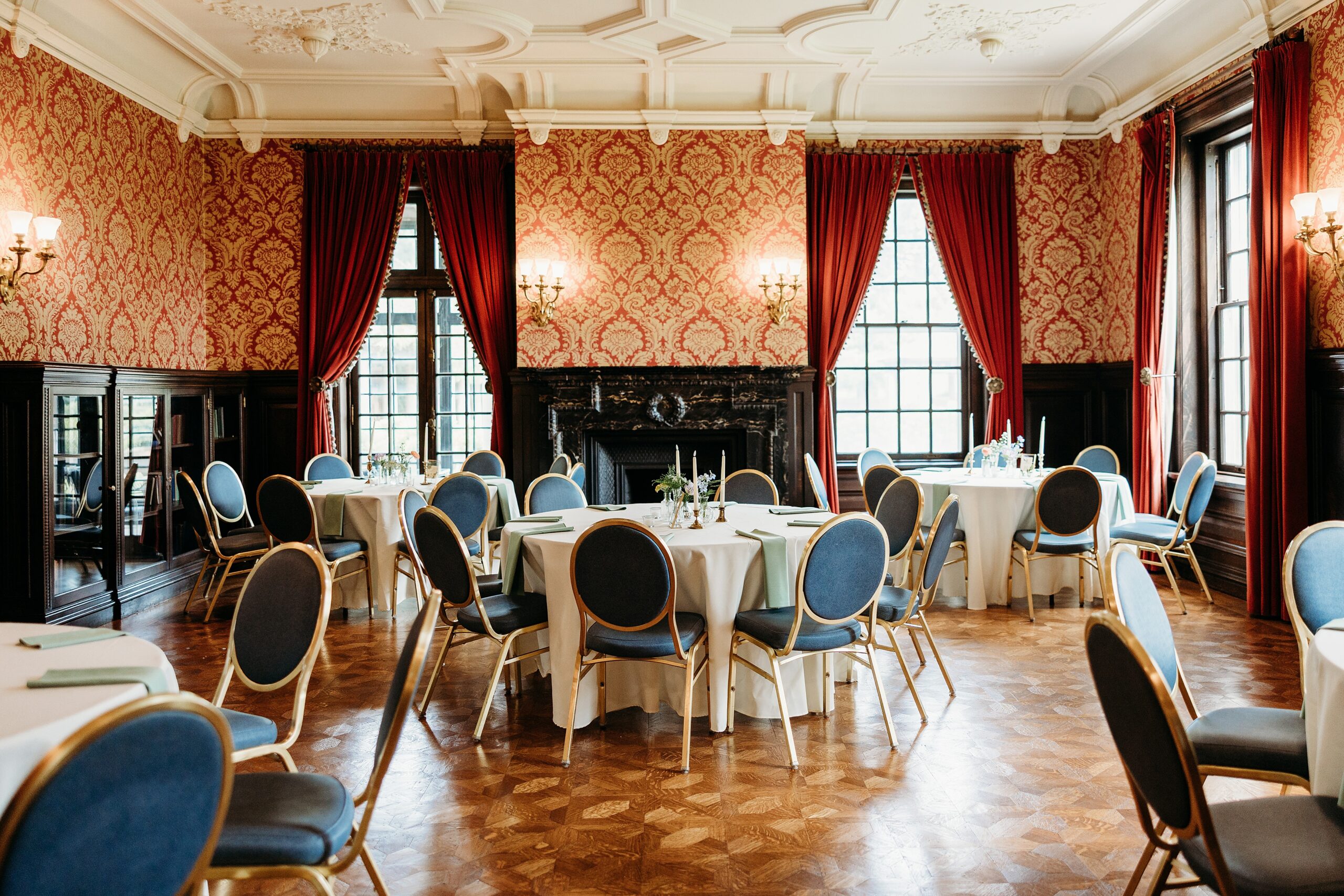 Garden Court formal reception room with ornate wallpaper, fireplace, and elegant wedding reception tables.