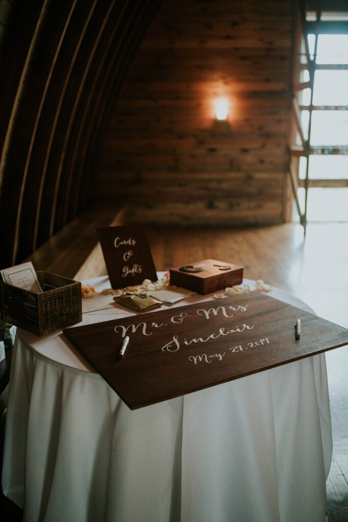 Yew Dell Gheens Barn wedding guest book sign in table with a personalized wooden guest book, cards and gift box displayed at the reception entrance.