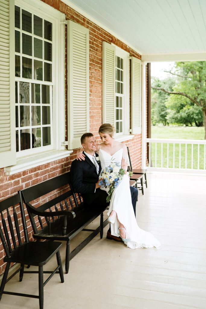 Bride and groom sitting on the front porch during their wedding portraits.