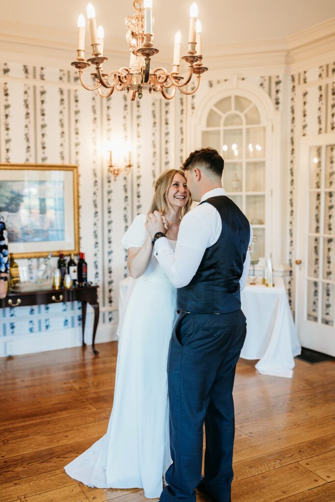 Couple shares their first dance inside elegant ballroom.