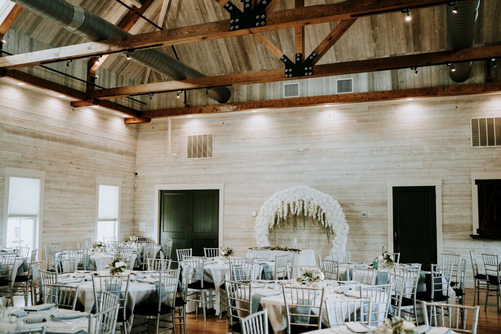 Reception space at the Carriage House at the Howard Steamboat Museum with a floral head table backdrop.