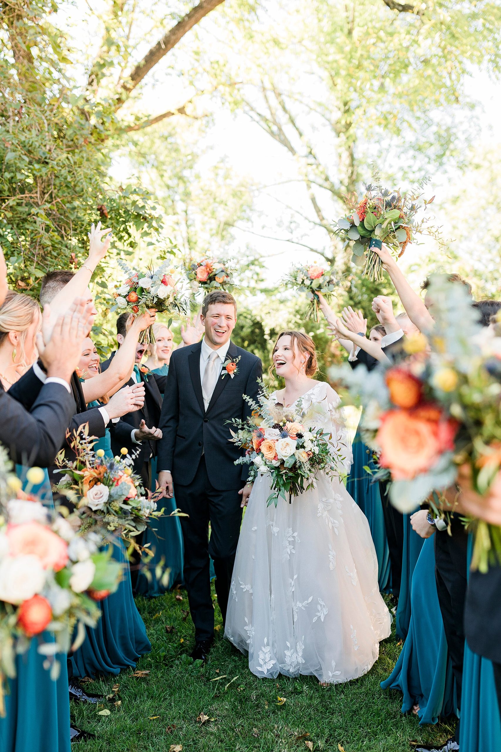 Wedding party cheering bride and groom on Gardencourt Lawn
