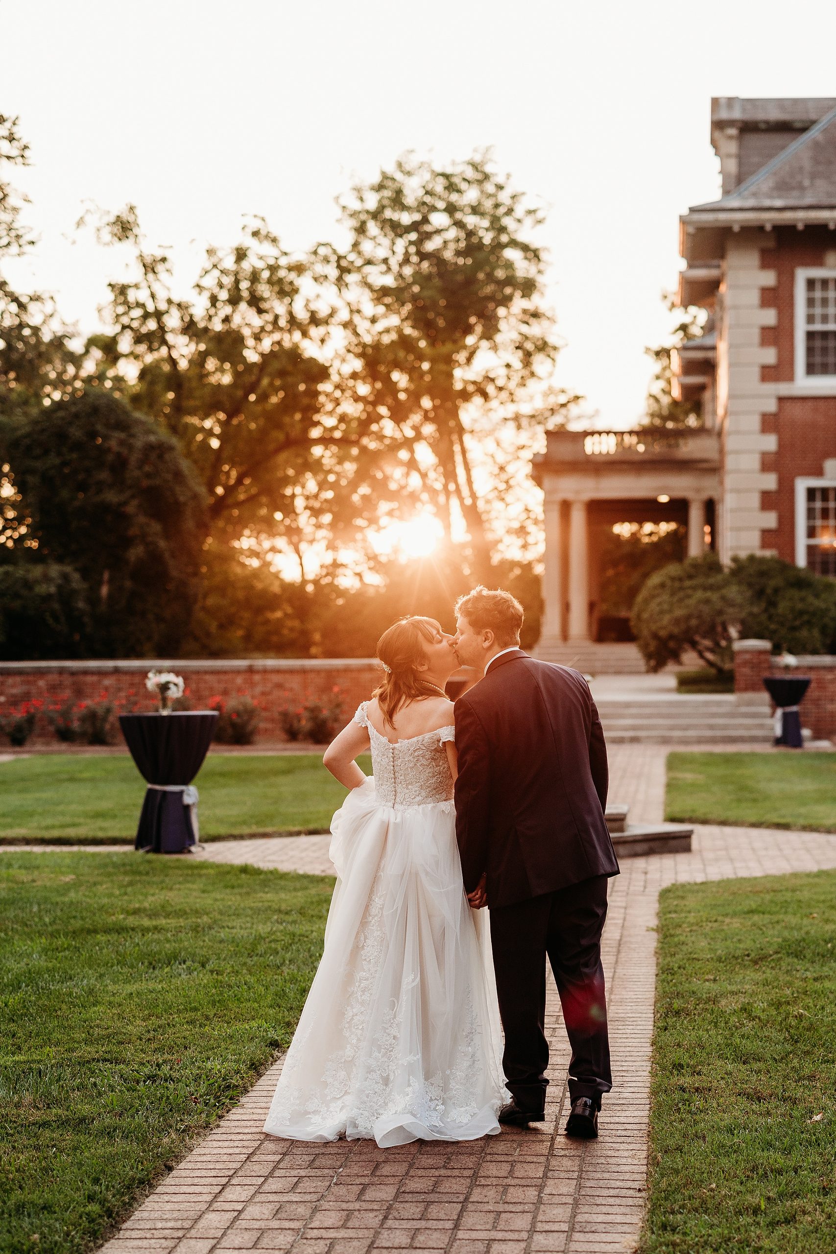 Bride and groom kiss at sunset during their Gardencourt wedding.