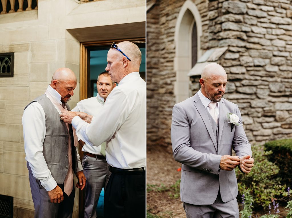 Groom gets help adjusting his tie before posing outside in a gray three-piece suit.