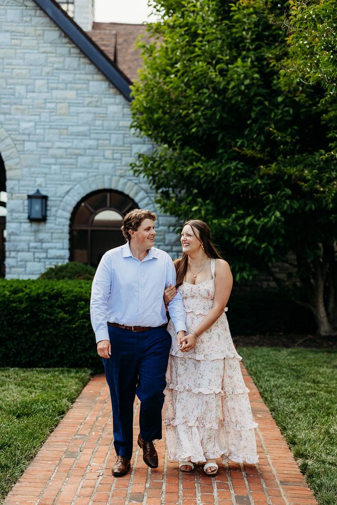 Engaged couple laughing together while walking hand in hand at Keeneland.