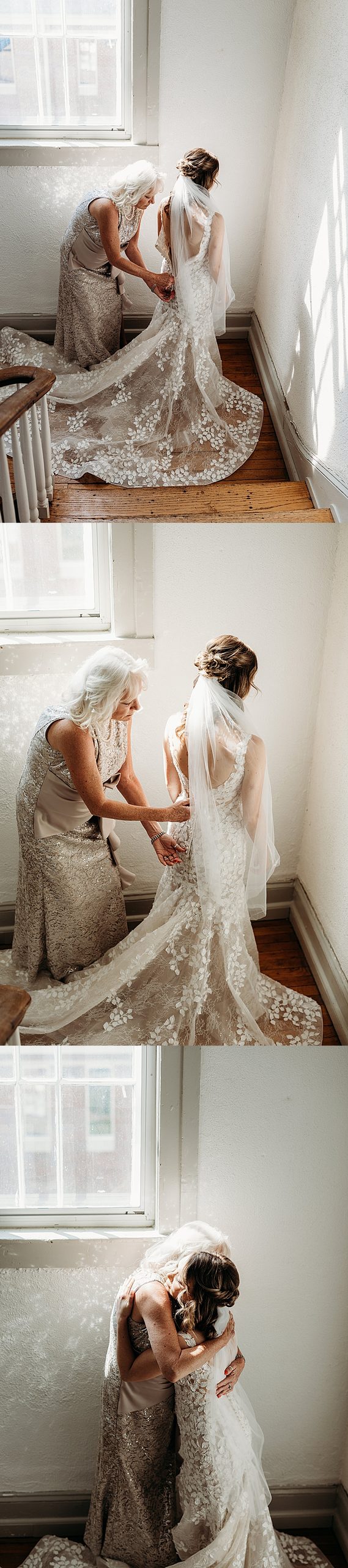 Mother helps the bride with her lace wedding dress before sharing an emotional hug.
