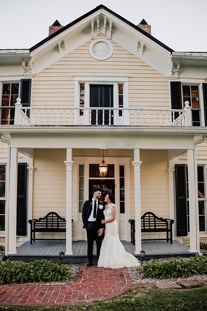 Newlyweds standing beneath the front porch of Bradshaw Duncan House.